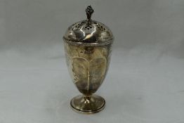 A silver caster of urn form having a pierced lid with pineapple finial, Birmingham 1926, Adie