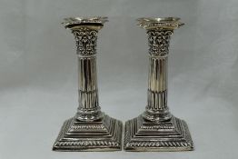 A pair of silver candle sticks of Corinthian column style having removable sconces, fluted columns