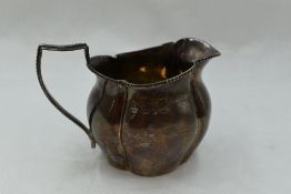 A small Victorian silver cream jug of goad form having beaded decoration to rim and handle, marks