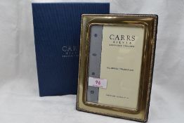 A modern silver photograph fame of rectangular form having beaded rim and blue velvet easel back,