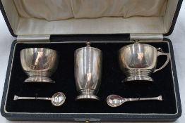A cased silver three piece cruet set having blue glass liners, Birmingham 1917, William Suckling