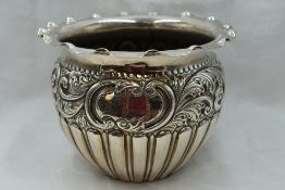 An Edwardian silver jardiniere having gadrooned decoration with repousse rose and scroll band,