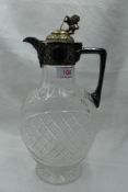 A cut glass claret jug of oval form having chequered decoration and plated handle and lid with