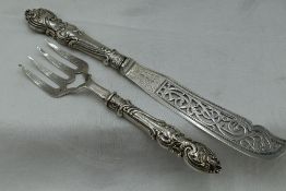 A pair of Victorian silver fish servers having moulded handles and pierced and engraved blades,