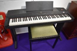 A Yamaha YPP-55 digital piano on integral stand, stool and small selection of sheet music books