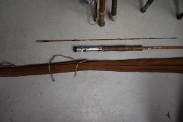 A three peice 10ft split cane fly rod with spare tip in canvas sleeve