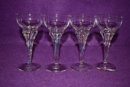 A set of four small vintage glasses, having colourful twisted stems.