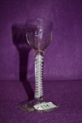 A cordial glass with moulded decoration to the bowl over stem with an opaque multi twist spiral at