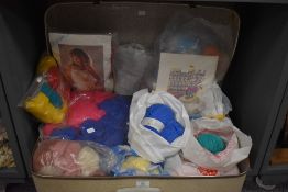 A retro suitcase containing various wools and knitting kits.