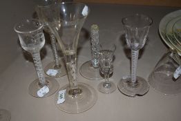 A collection of six antique glass including etched wine glasses with multi spiral twists to stems,