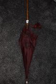 An antique red parasol, having bambo handle.AF