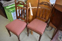 A pair of Victorian dining chairs having overstuffed seats