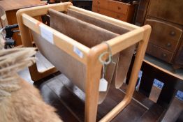 A vintage beech and suede magazone rack of stylised form