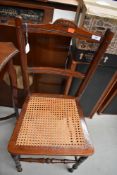 A late Victorian stained frame bedroom chair, having typical cane seat on turned frame