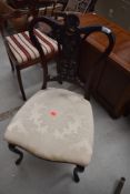 A Victorian mahogany salon chair having foliate shield back