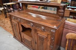 A Victorian oak sideboard, having carved panel and mask handles and mirrored ledge back, width