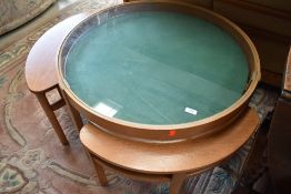 An interesting vintage coffee table, having glass enclosed beize top nesting three eye shaped