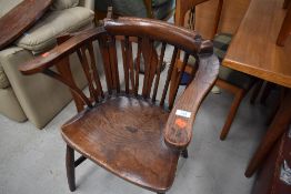 A late 19th/early 20th Century oak comb back smokers bow style carver chair