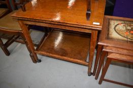 A mid 20th Century oak tea trolley havin folder over top, lined with green beize, approx closed