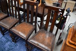 A set of four early 20th Century oak rail back dining chairs and drawer leaf dining table