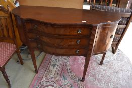 A reproduction Regency sideboard having serpentine front, three central drawers flanked by cupboards