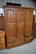 A modern pine triple wardrobe, Kenilworth farmhouse design, having drawer base, width approx. 140cm