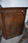 A 19th century oak corner cupboard having panel door, approx width 76cm