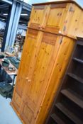 A modern pine wardrobe, with upper cupboard section