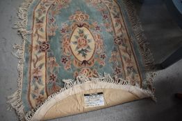 A vintage oval rug, by St Michael, Green Mandarin pattern, approx 152 x 91cm