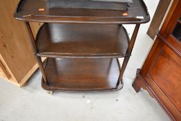 A dark stained Ercol tea trolley, on large shepherds casters