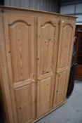 A modern triple wardrobe in natural pine, approx. width 135cm