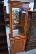 A reproduction yew wood display cabinet with single cupboard under, of narrow proportions, approx.