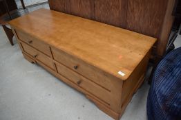 A modern light stained ottoman/bedding box having lift top and dummy drawer fronts, would also
