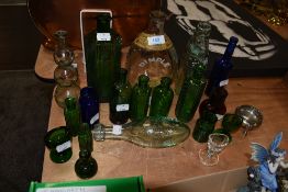 A collection of glass medical bottles, eye baths, codd bottles and more.