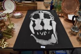 An abstract black and white canvas, having nudes in formation of skull.