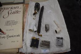 A selection of opium pipes and clay pipes having decorated bowls, also three vintage lighters.