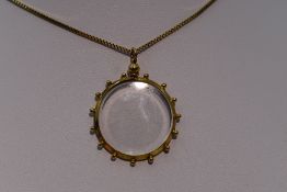 A glass locket in a decorative 9ct gold mount on a 9ct gold box chain, approx 17'
