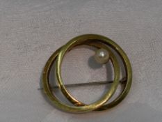 A yellow metal double loop brooch stamped 585 having cultured pearl decoration