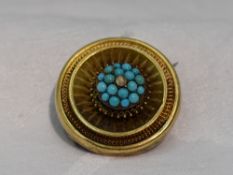 A Victorian yellow metal brooch having a turquoise and seed pearl set cluster centre within a