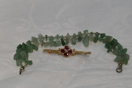 A 9ct gold bar brooch having ruby and diamond chip decoration and a Jade style bracelet (AF)