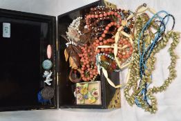 A Chinese style jewellery box having brass fitments and containing a selection of costume