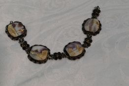 A white metal filigree bracelet having four conche shell cameo panels bearing Middle Eastern