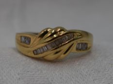 A lady's dress ring having channel set baguette cut diamonds in a moulded wave style setting on a