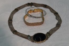 A white metal multi strand necklace having central oval onyx panel and black enamelled connector