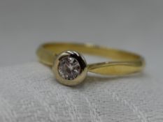 A lady's diamond solitaire dress ring, approx 0.25ct in a collared mount on an 18ct gold loop,