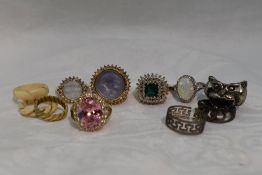 A selection of fashion rings of various designs including cherub, moonface, faux opal etc, some