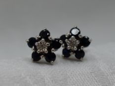 A pair of diamond and sapphire daisy cluster stud earrings in 9ct white gold mounts