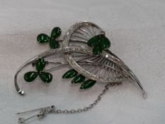 A white metal brooch stamped 18K modelled as a stylised sprig of flowers having diamond and