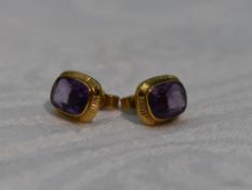 A pair of amethyst stud earrings having yellow metal collared mounts, no marks tested as 9ct gold