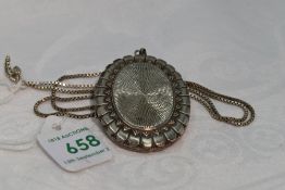 An HM silver locket of oval form having moulded decoration, on silver box chain